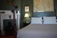 Queen bed in room with dark green walls